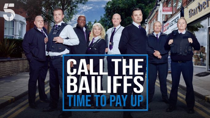 Group of bailiffs standing outside a shop, promoting a show titled "Call the Bailiffs: Time to Pay Up."