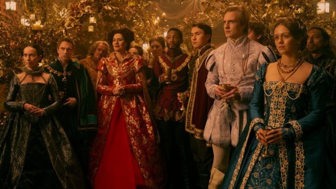 A group of elegantly dressed people in historical costumes at a formal event.